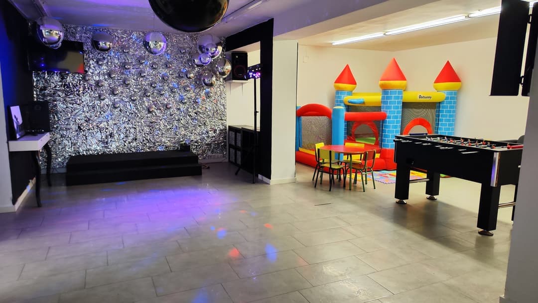 Pista de baile con pared de espejos, bola de discoteca y luces de colores